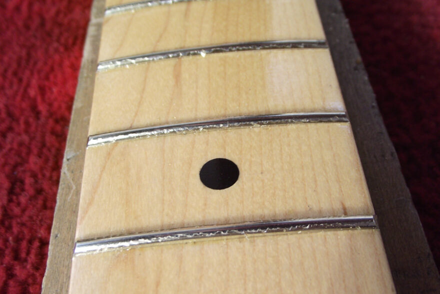 Showing the frets scraped clear of lacquer
