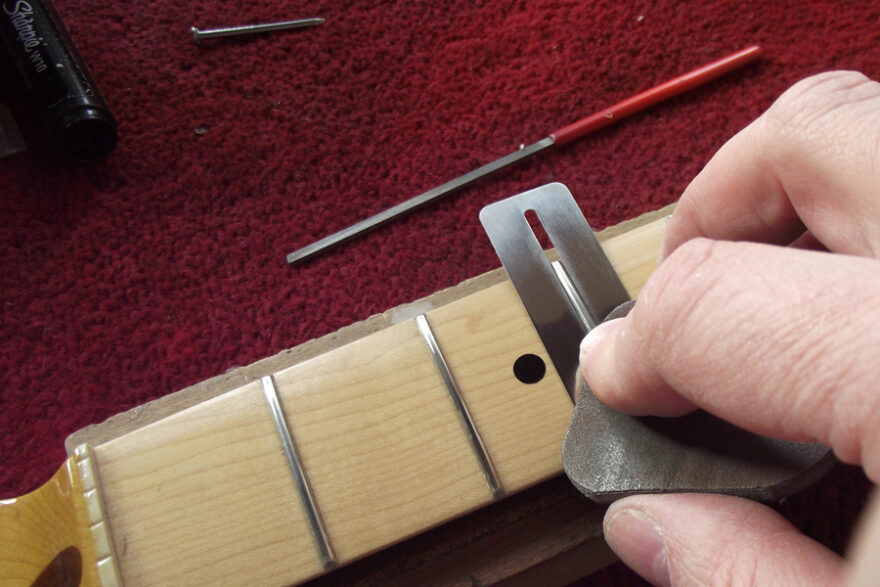 Dressing the frets on the maple neck Manchester Guitar Tech