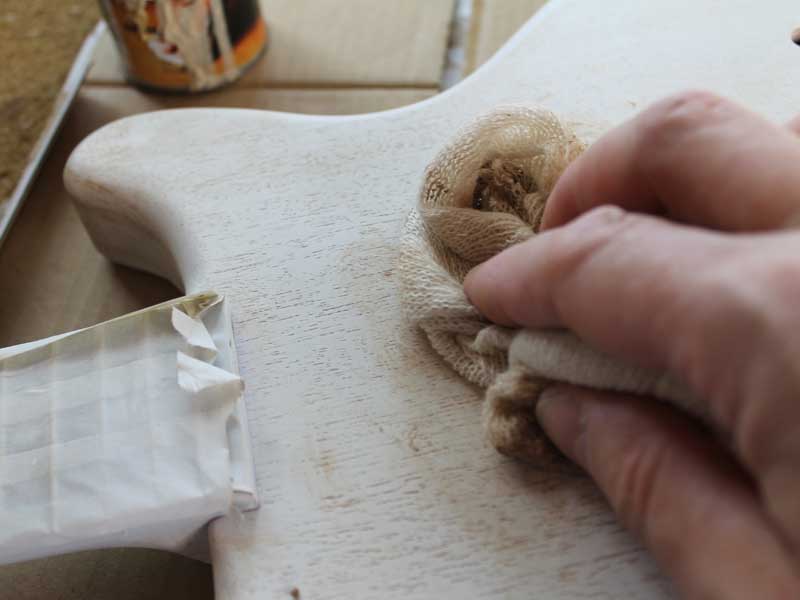 Applying the grain filler using a piece of mutton cloth